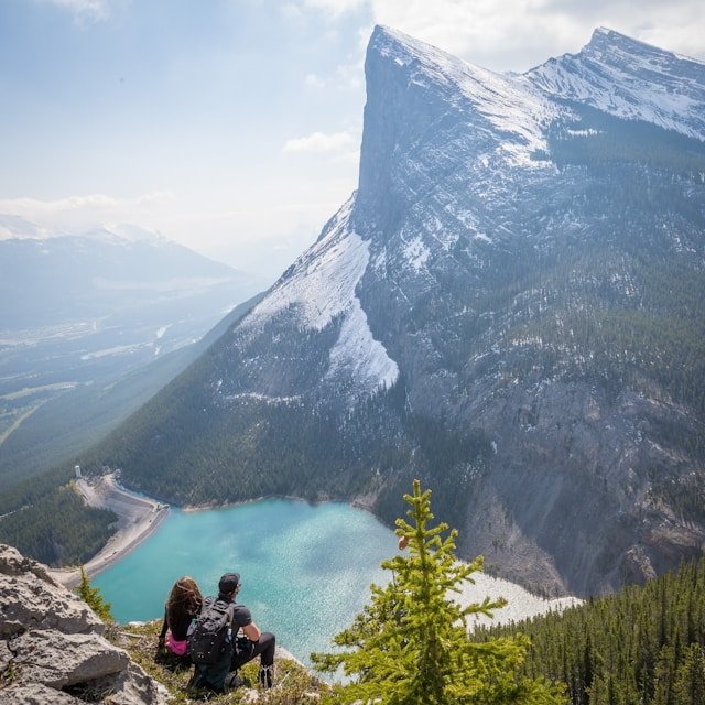 Two people sitting on a mountain